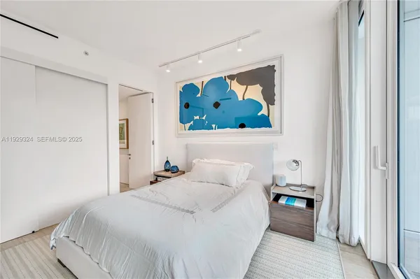 a bedroom with a bed and a painting on the wall