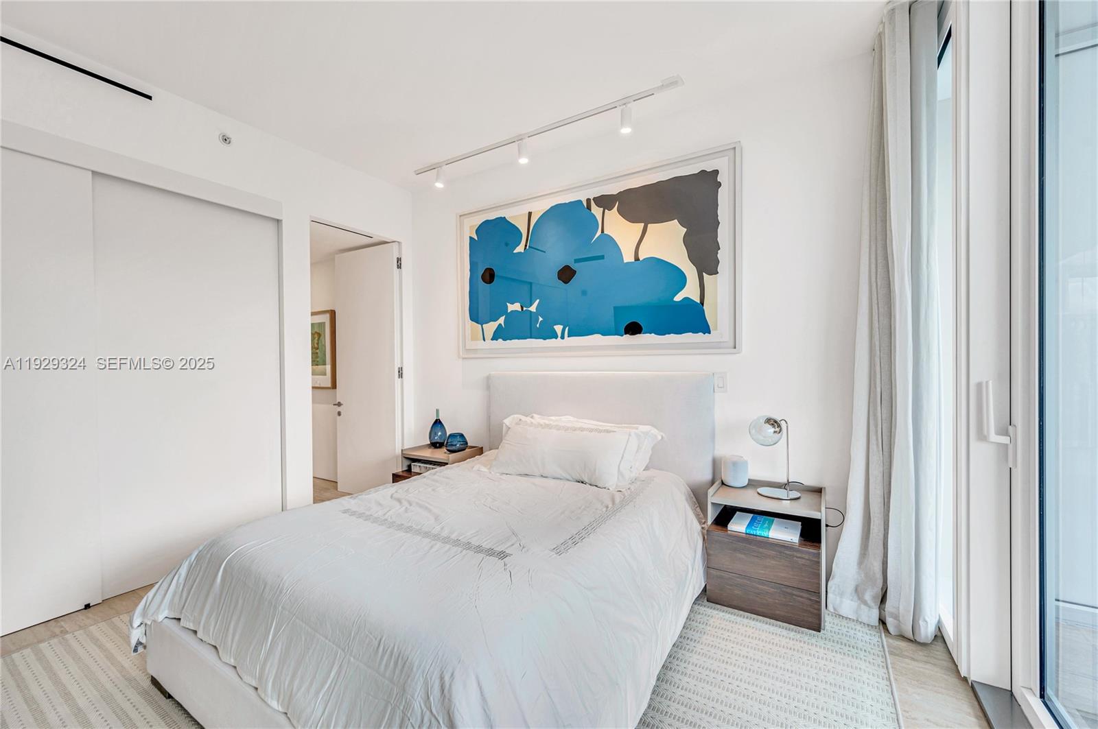 9111 Collins Avenue, Unit N322 Surfside, FL 33154 - Photo 13 of 23 a bedroom with a bed and a painting on the wall