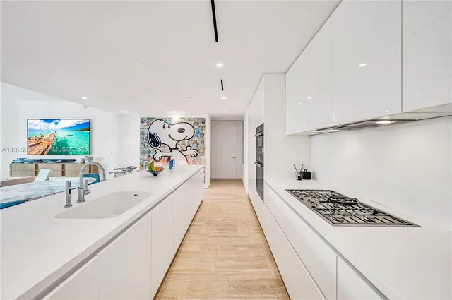 a large white kitchen with a large window