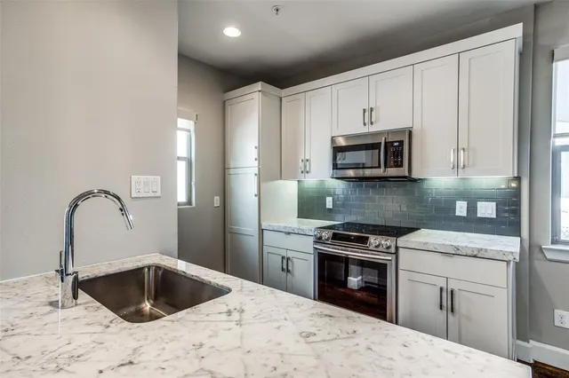 a kitchen with granite countertop a stove sink and microwave