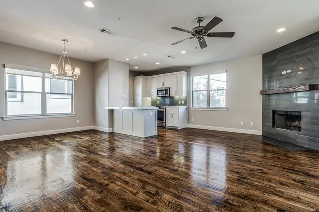 a view of an empty room with a kitchen and a window