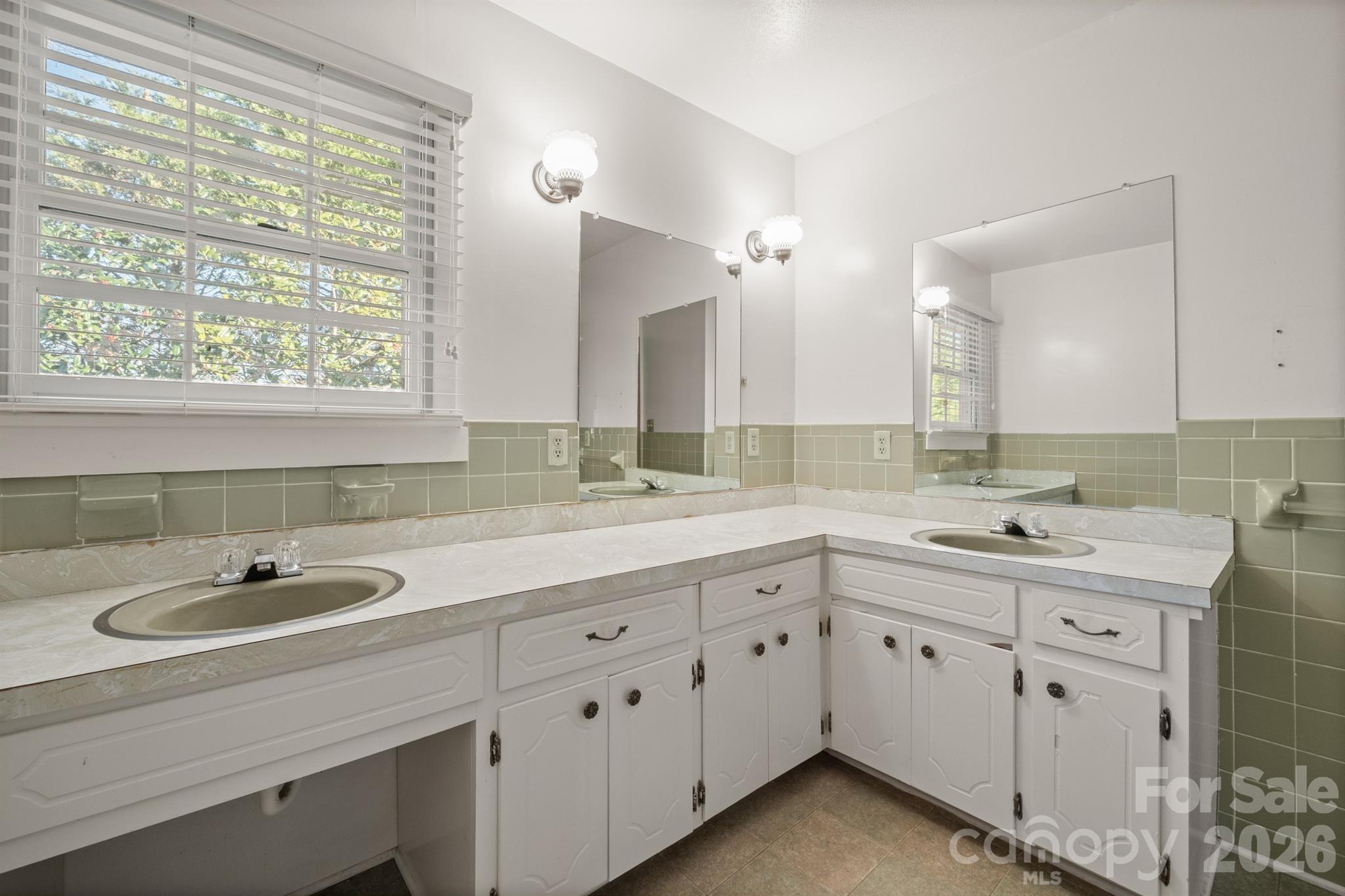 482 Miller Farm Road Statesville, NC 28625 - Photo 18 of 46 a bathroom with a double vanity sink and mirror with window
