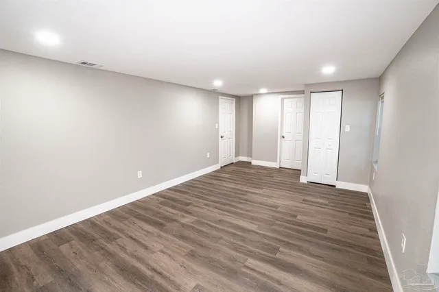 a view of an empty room with wooden floor