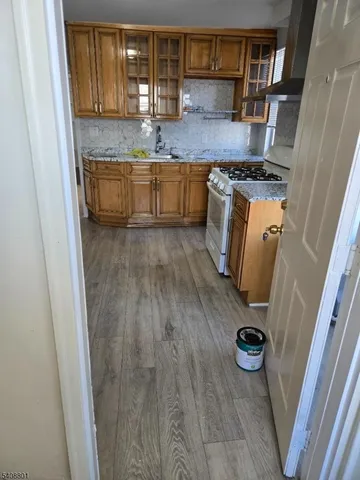 a kitchen with granite countertop a sink stove and cabinets