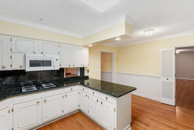 a kitchen with granite countertop a stove a sink and a refrigerator