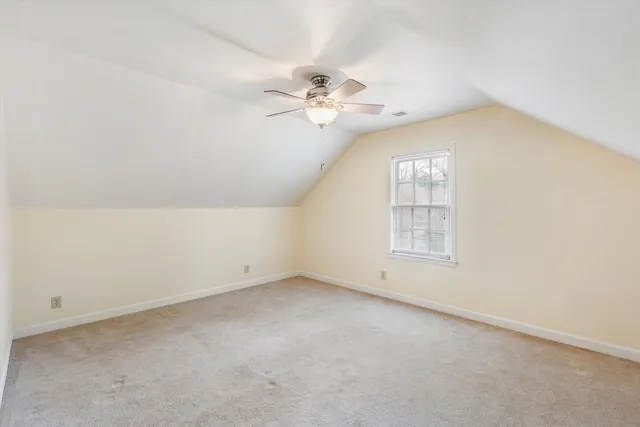 an empty room with a window and a ceiling fan