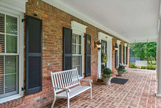 a view of a house with a chairs and table in a patio