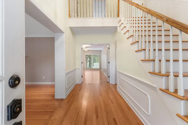 a view of a hallway with wooden floor and staircase