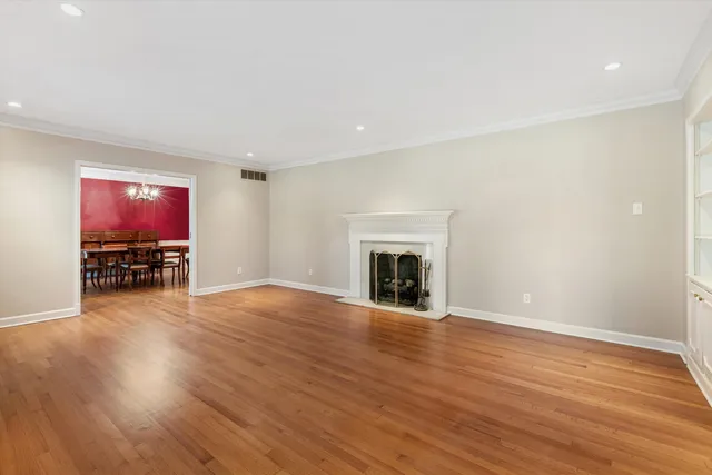 a view of empty room with wooden floor and fireplace