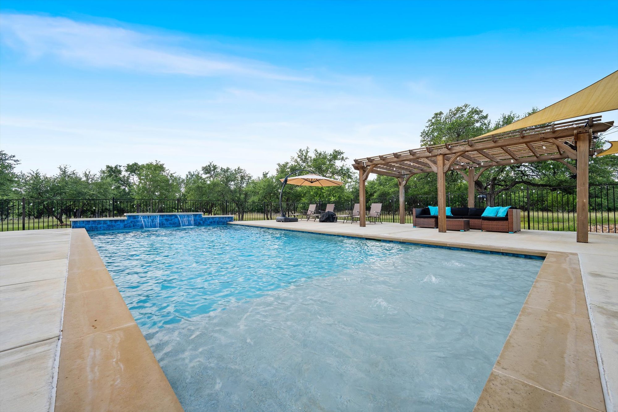 638 Strada Luca Florence, TX 76527 - Photo 29 of 38 Relax poolside under the shaded pergola, surrounded by lush landscaping.