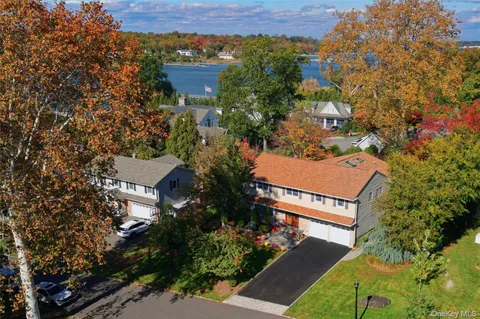 an aerial view of a house with a yard and tree s