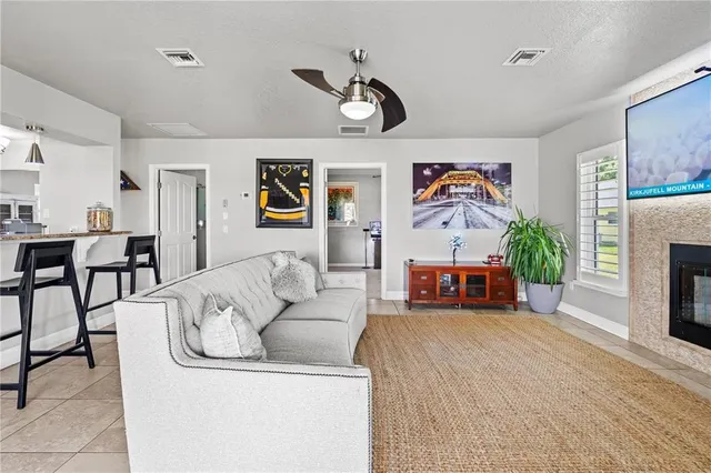a living room with furniture a fireplace and a floor to ceiling window