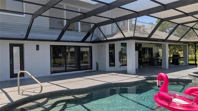 a bedroom with a bed next to a large window with wooden floor