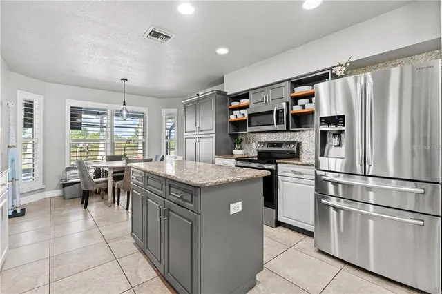 a kitchen with granite countertop sink stove and center island