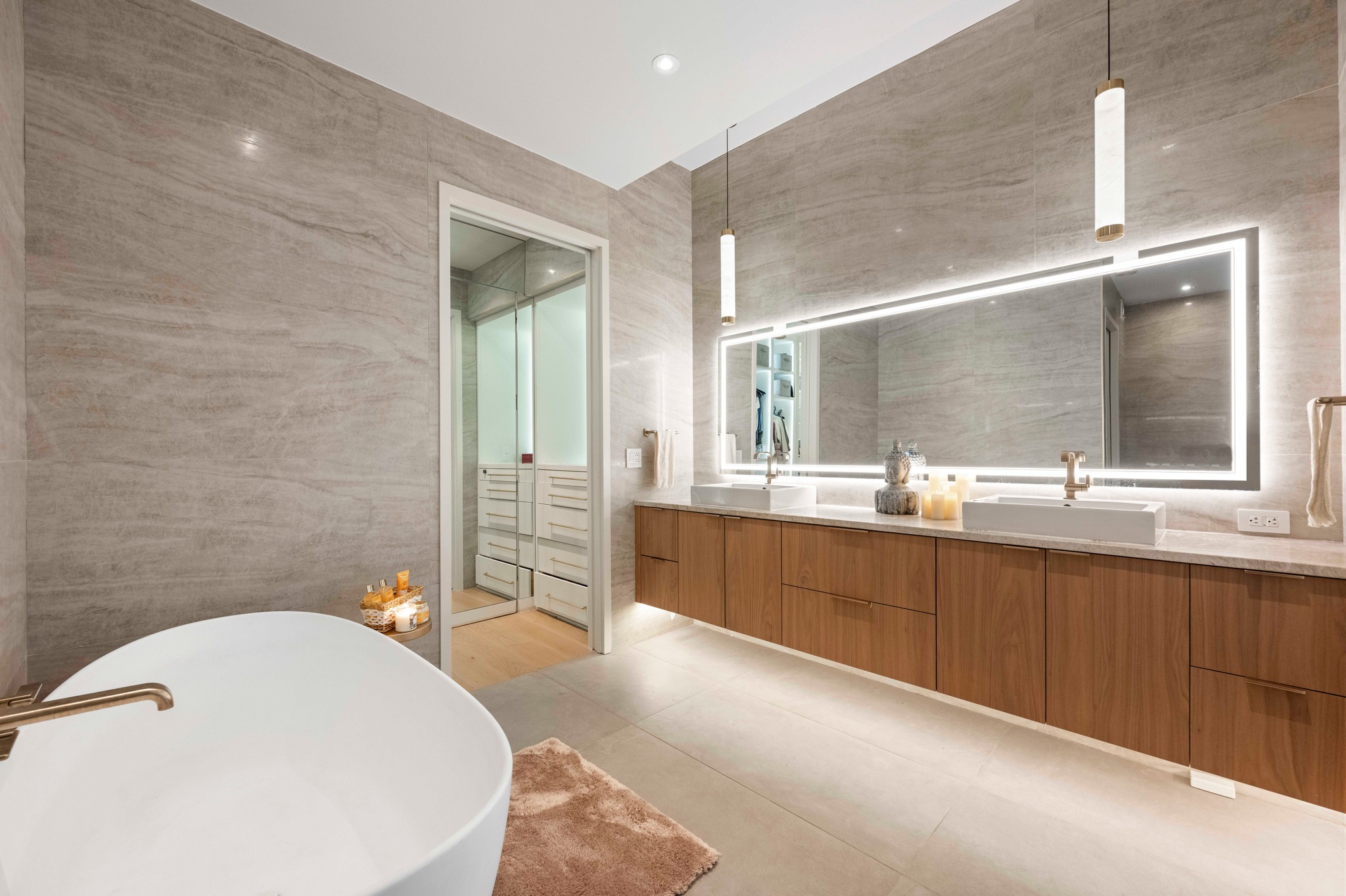 210 Lavaca Street, Unit 2706 Austin, TX 78701 - Photo 10 of 32 Bathroom featuring a freestanding soaking tub with a floor-mounted faucet, a double vanity with an integrated countertop, and a large illuminated mirror