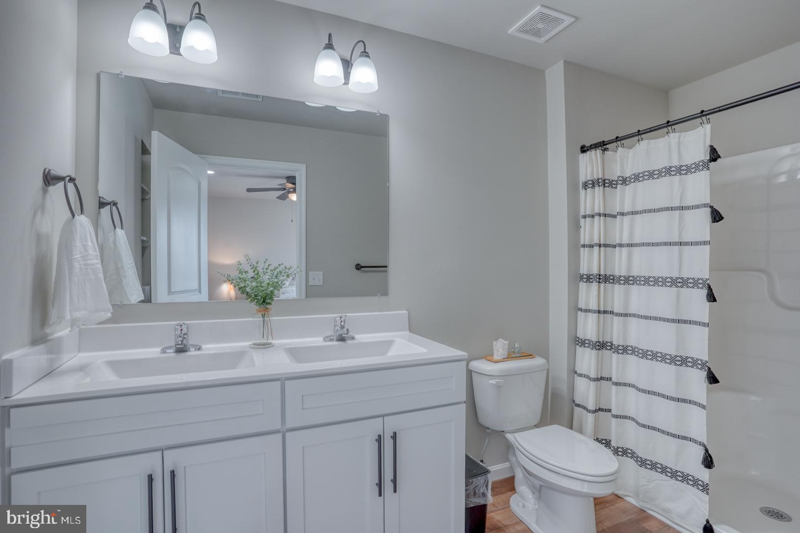 234 Rojan Road, Unit 13 Dover, DE 19901 - Photo 4 of 17 a bathroom with a sink a toilet a shower and a mirror