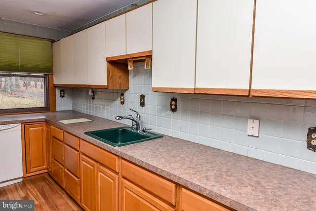 a living room with wooden floor furniture and a large window
