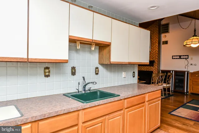 a living room with stainless steel appliances kitchen island granite countertop a stove a sink and a refrigerator