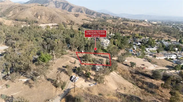 an aerial view of house with yard and mountain view in back