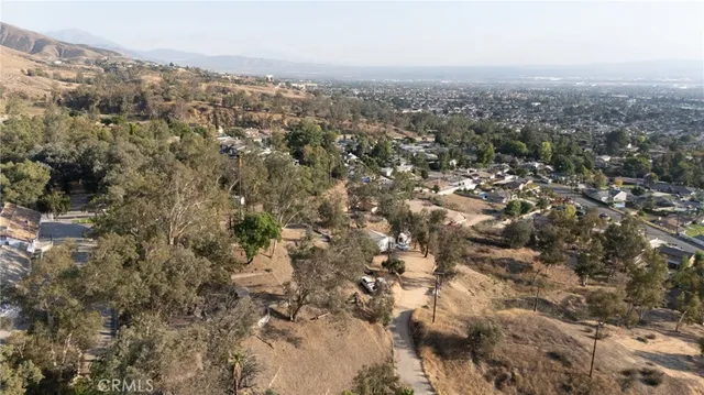 an aerial view of residential house with beach and trees all around