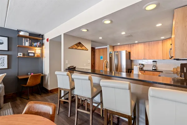 a kitchen with stainless steel appliances kitchen island granite countertop furniture and a refrigerator