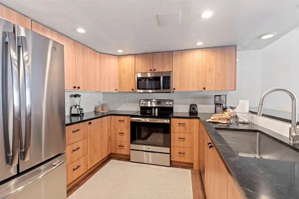 a kitchen with stainless steel appliances granite countertop a refrigerator sink and cabinets
