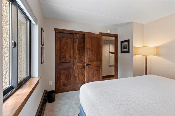 a bedroom with a bed and a large mirror
