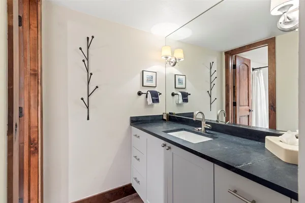a bathroom with a granite countertop sink and a mirror