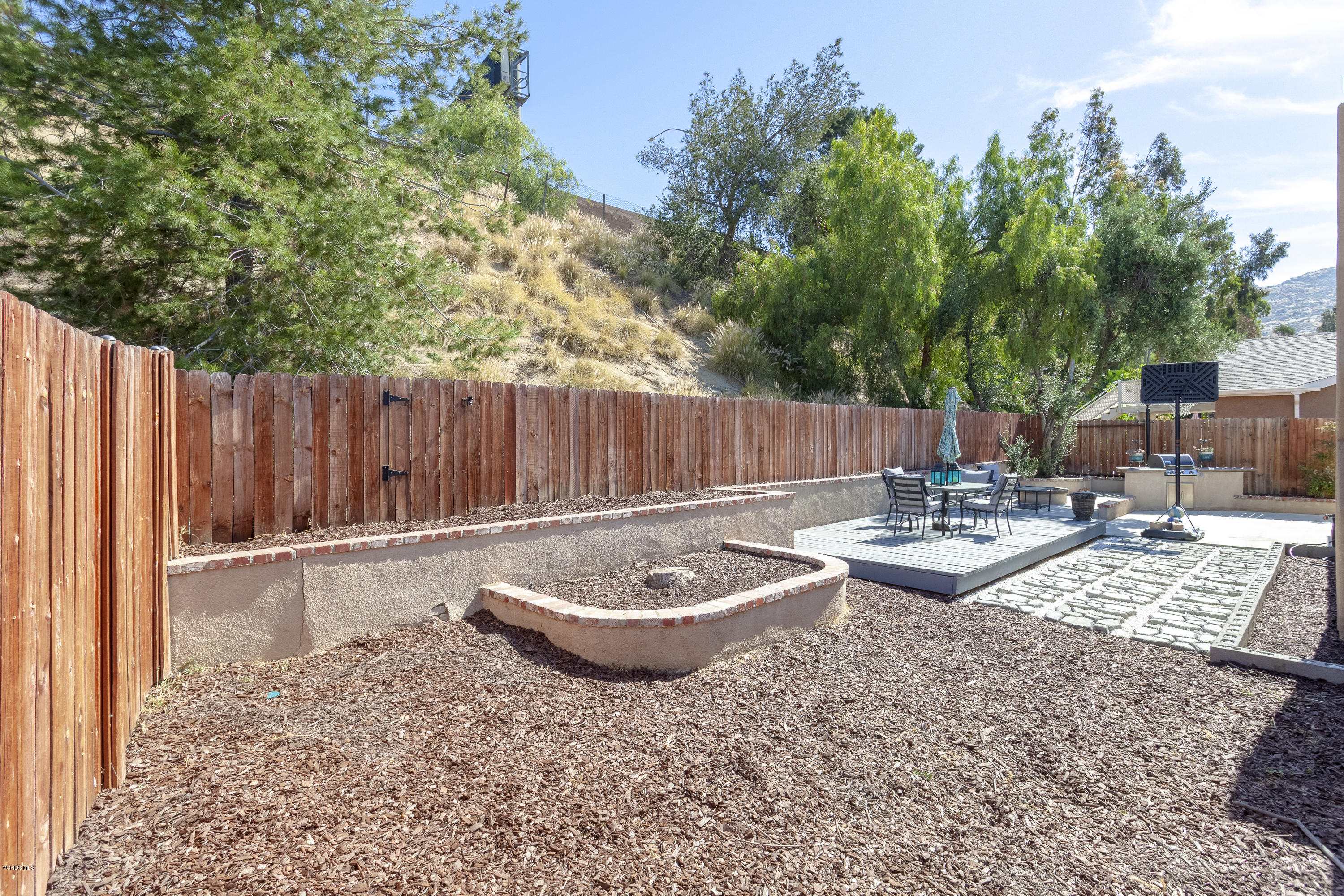 6349 Keystone Street Simi Valley, CA 93063 - Photo 22 of 24 a view of a backyard with table and chairs and couches with wooden fence and plants