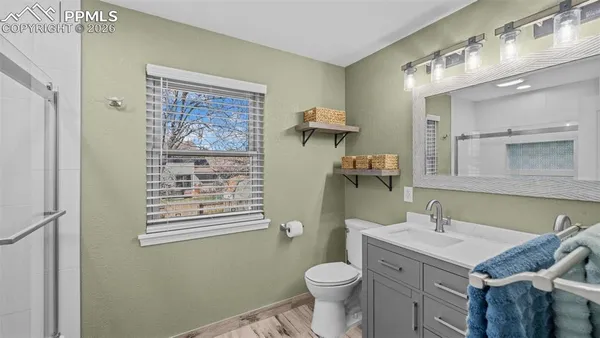 a bathroom with a granite countertop toilet a sink and a mirror