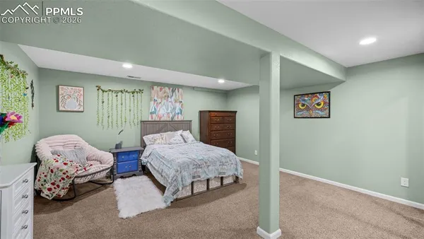 a spacious bedroom with a bed and a dresser