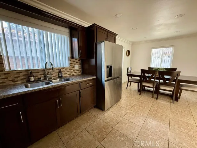 a kitchen with stainless steel appliances granite countertop a sink counter space and chairs