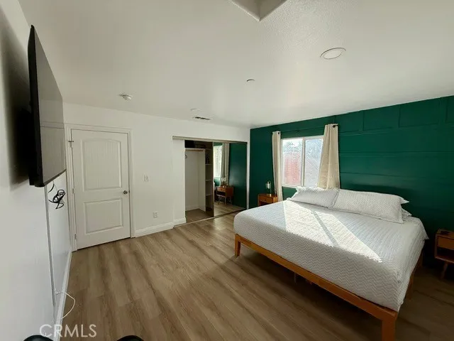 a spacious bedroom with a bed and a flat screen tv