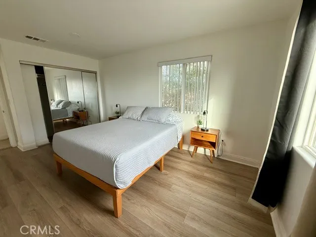 a bedroom with a bed and wooden floor