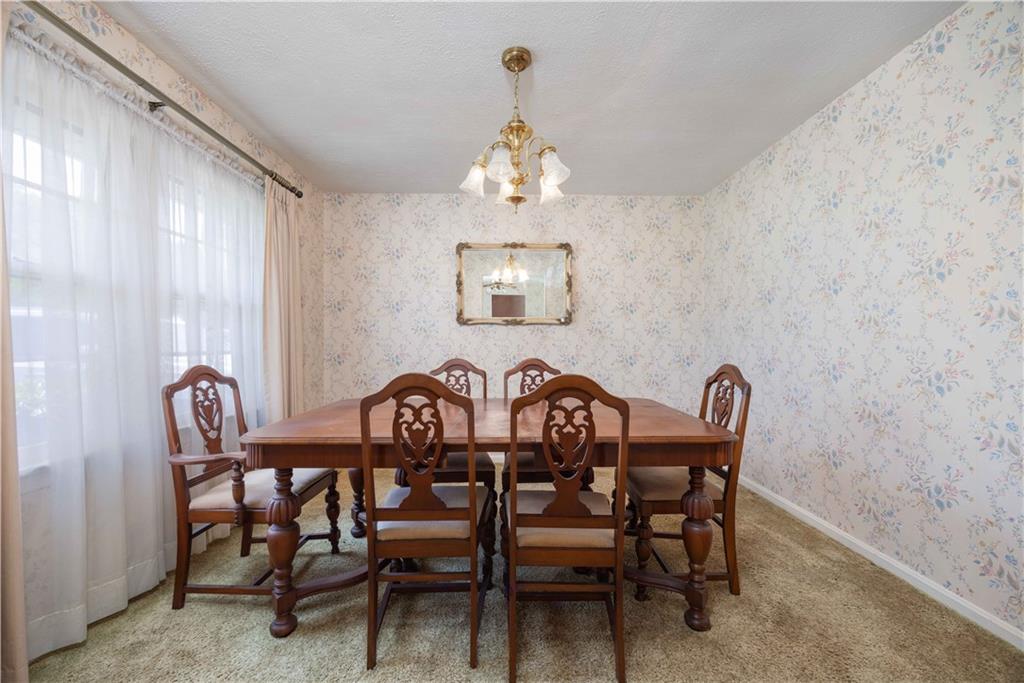 5201 Summerville Road Phenix City, AL 36867 - Photo 17 of 35 Dining area featuring a chandelier, carpet floors, wallpapered walls, and baseboards