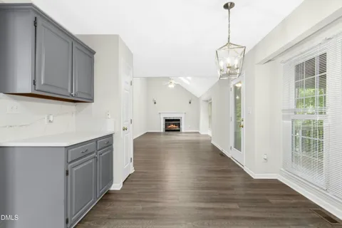 a large kitchen with cabinets a counter space a sink and wooden floor
