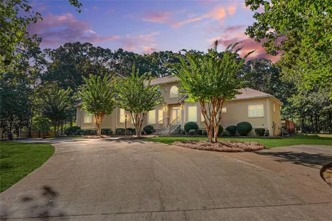 a front view of a house with a yard and trees