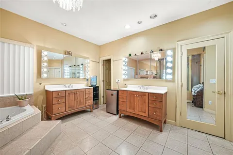 a spacious bedroom with a bed a couch and a chandelier