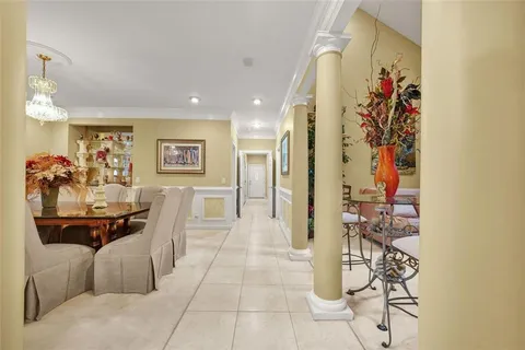 a open kitchen with stainless steel appliances granite countertop a stove top oven a sink a dining table and chairs with the cabinets