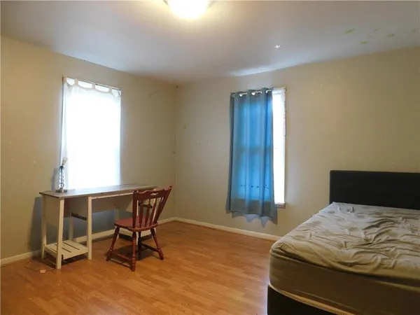 a bedroom with a bed a chair and a window