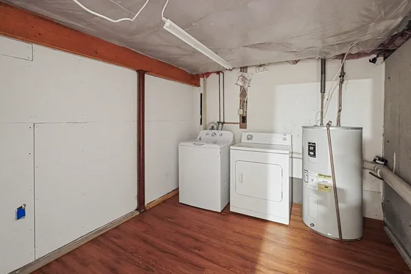 a utility room with wooden floor washer and dryer