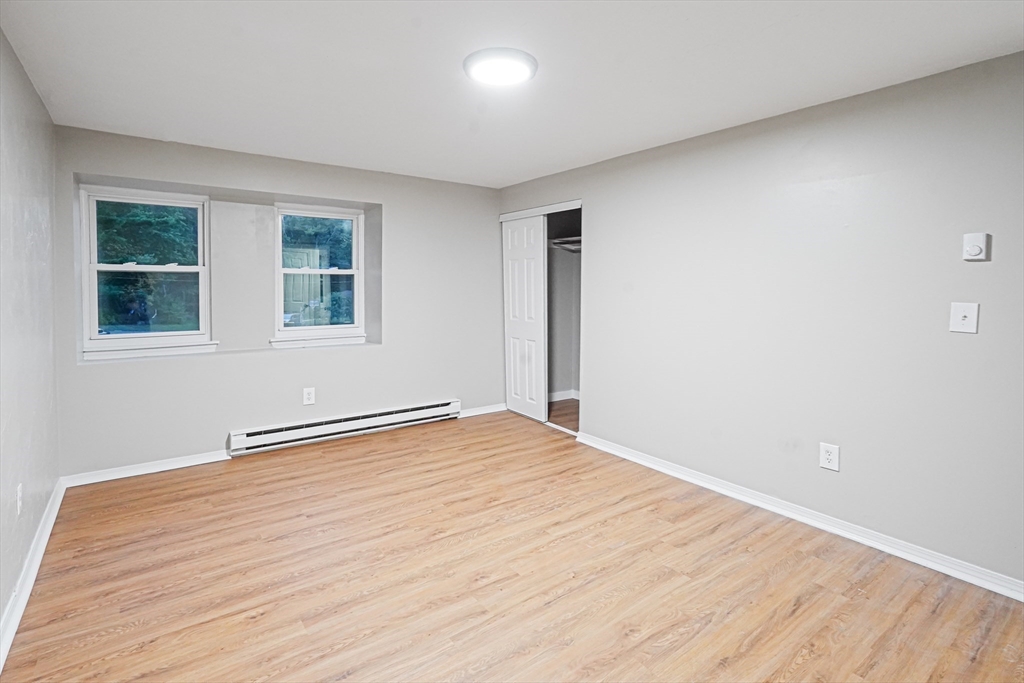 7 Debra Lane, Unit 1 Bellingham, MA 02019 - Photo 19 of 25 a view of an empty room with wooden floor and a window