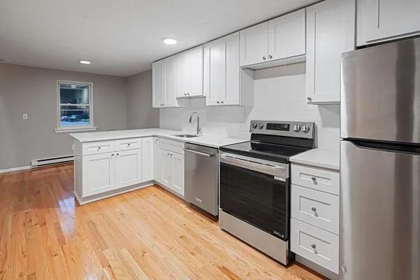 a kitchen with a refrigerator stove and white cabinets