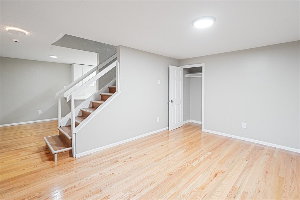 7 Debra Lane, Unit 1 Bellingham, MA 02019 - Photo 8 of 25 a view of an empty room with wooden floor and stairs
