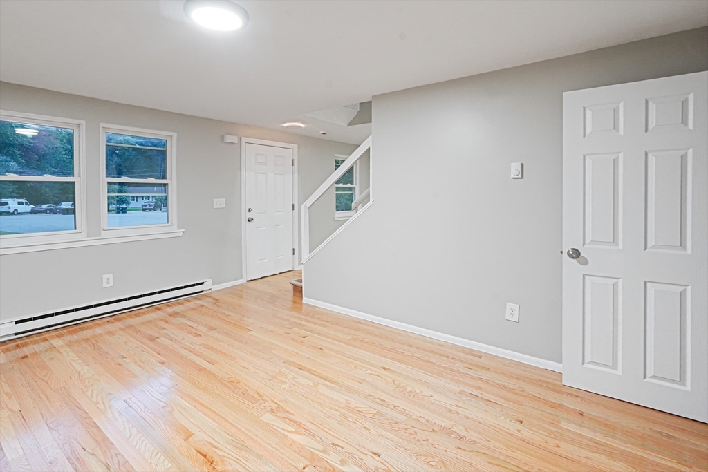 7 Debra Lane, Unit 1 Bellingham, MA 02019 - Photo 9 of 25 a view of an empty room with wooden floor and a window