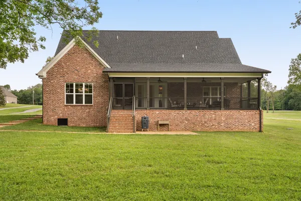 a front view of a house with a yard and trees