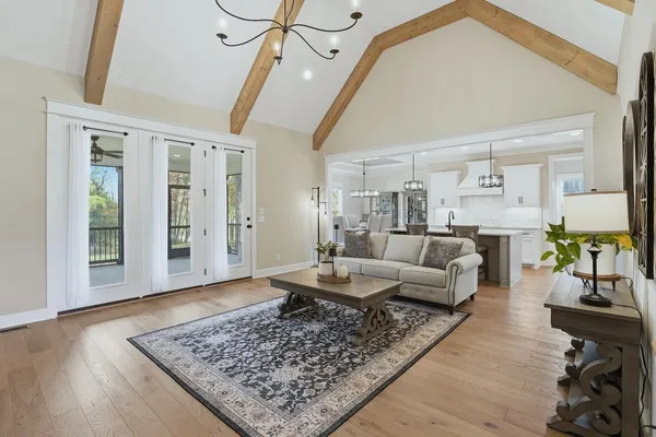 a kitchen with stainless steel appliances kitchen island granite countertop a table chairs in it and white cabinets