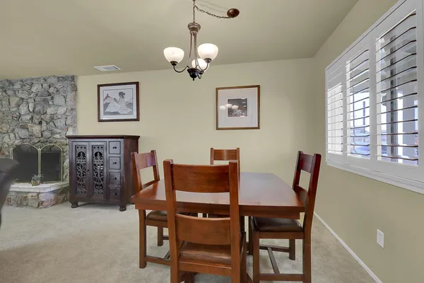 a view of a dining room with furniture and chandelier