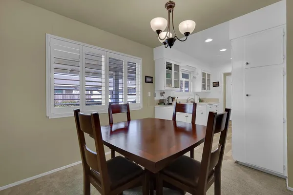 a view of a dining room with furniture a chandelier and window