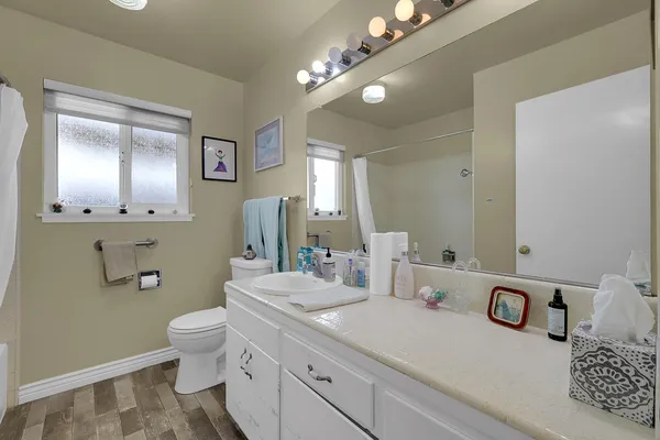 a bathroom with a granite countertop toilet and sink
